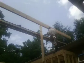 Carpenter setting a ridge beam over a new addition frame — Ice Dam Removal by Roofing Brothers in Parkesburg