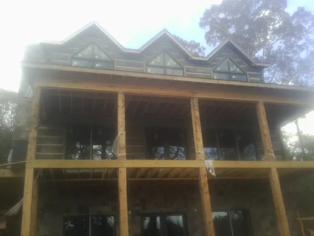 Dormers and porch framing on a large log home under construction — Roof Coating work by our crew in Parkesburg