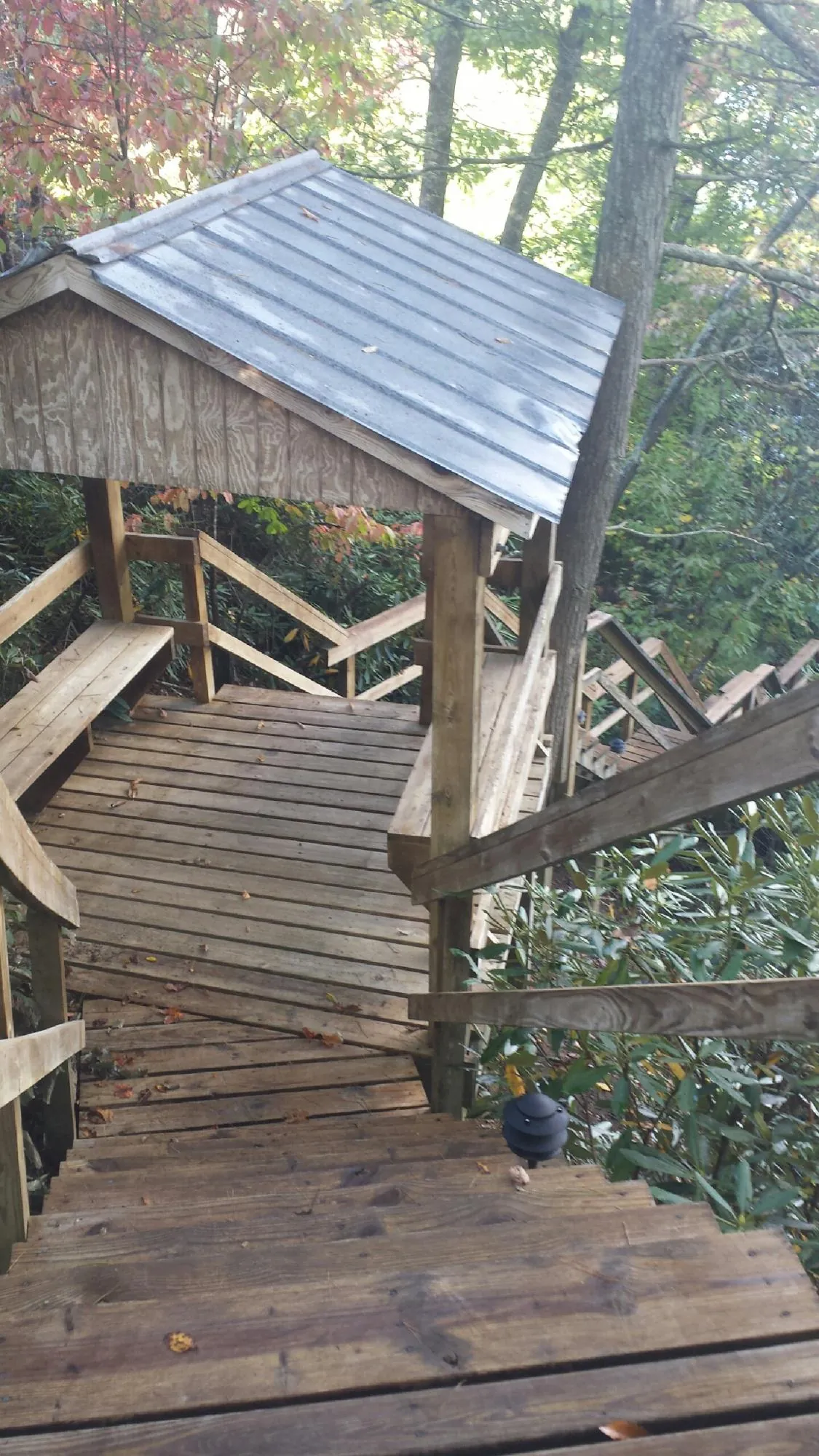Metal roofed shelter over wooden steps on a wooded walkway — Skylight Repair & Installation work by our crew in Parkesburg